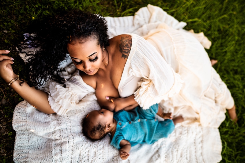 Maternity Photographer, a woman breastfeeds her young child